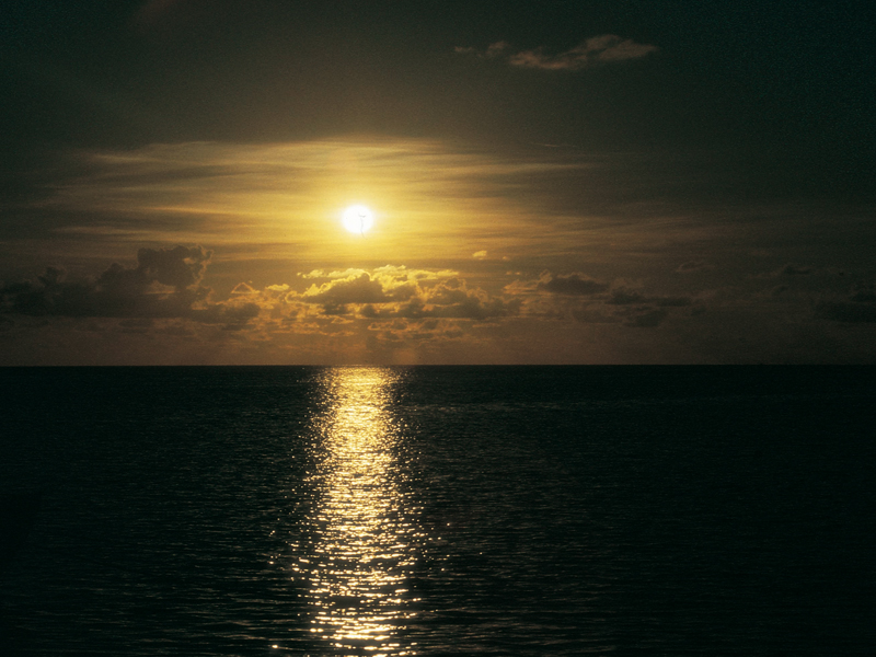 Bild eines Sonnenunterganges über dem dunklen Meer.
