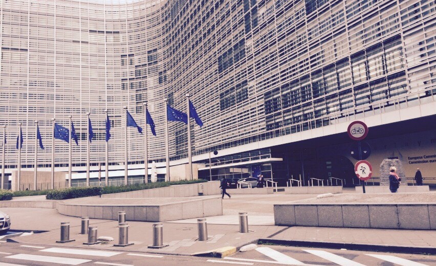 Blick von der Straße auf das Gebäude der EU-Kommission in Brüssel, Eu-Flaggen wehen vor dem Gebäude.