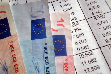 Mehrere Euro-Scheine liegen auf einem Blatt mit einer Kalkulation.