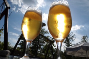 Zwei aus der Froschperspektive aufgeniomme Tulpengläser mit Bier in der Sonne.