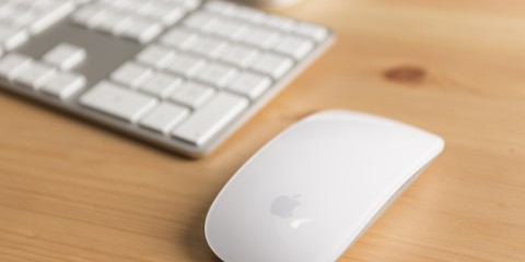 Detailaufnahme einer modernen Computertastatur und der dazugehörigen Mouse in weiß von Apple.