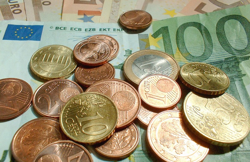 Nahaufnahme verschiedener Euro-Gelscheine und -Münzen.