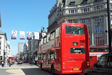 Bild von einem der brühmten roten Doppeldeckerbusse, der durch London fährt.